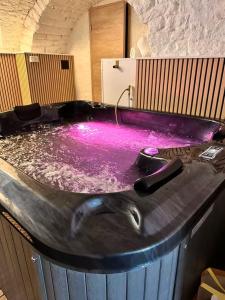 a large purple bath tub in a room at Jacuzzi des Voutes in Vesoul +1 photo