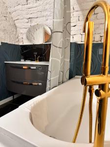 a bathroom with a white tub and a sink at Jacuzzi des Voutes in Vesoul