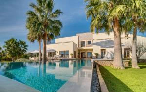 a swimming pool in front of a house with palm trees at Son Sard Nou in Son Servera