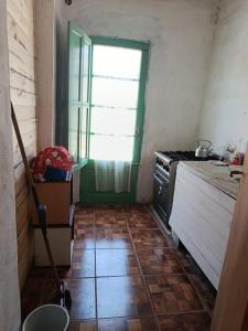 a kitchen with a green door and a stove at La esquina in Olavarría