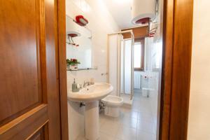 a white bathroom with a sink and a toilet at Casa Wanda LAWANDA in Oristano