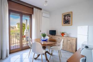 a dining room with a table and chairs and a balcony at Casa Wanda LAWANDA in Oristano