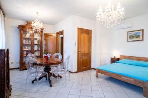 a bedroom with a table and a bed and a chandelier at Casa Wanda LAWANDA in Oristano