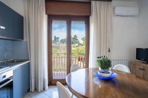 a kitchen with a wooden table and a balcony at Casa Wanda LAWANDA in Oristano +33 photos