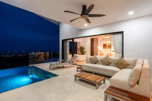 a living room with a couch and a ceiling fan at Savaya Samui Villa in Ban Ko Khwan
