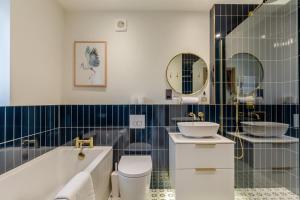 a bathroom with a tub and a toilet and a sink at 2 Bed in Melplash oc-r30043 in Netherbury +12 photos