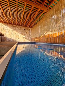 a swimming pool with blue water in a building at צימרים מול הנוף in Yarka