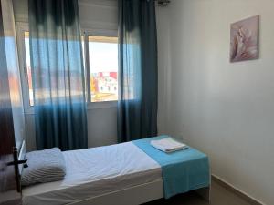a small bedroom with a bed and a window at Casandalus in Larache