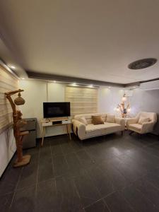 a living room with two couches and a flat screen tv at צימרים מול הנוף in Yarka