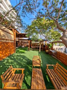 two wooden benches sitting on the grass in a yard at צימרים מול הנוף in Yarka