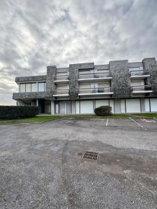a large building with a parking lot in front of it at appartement à Sainte Cecile in Camiers