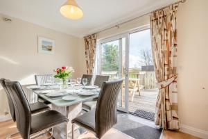 a dining room with a table and chairs and a balcony at 3 Bed in St. Merryn oc-r30137 in Saint Merryn