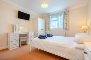a bedroom with a bed and a desk and a television at 3 Bed in St. Merryn oc-r30137 in Saint Merryn
