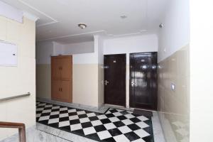 a bathroom with two doors and a checkered floor at Hotel O Mehtab Regency in Rewāri
