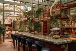 a bar in a restaurant with lots of plants at Rosewood Amsterdam in Amsterdam