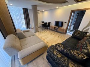 a living room with a couch and a tv at Beyaz Suites in Midyat