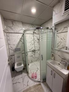 a bathroom with a shower and a toilet and a sink at Beyaz Suites in Midyat