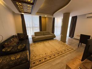 a living room with a couch and a rug at Beyaz Suites in Midyat