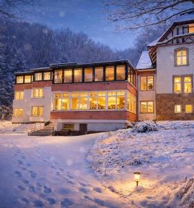 a large house in the snow at night at Waldhotel Bad Münstereifel in Bad Münstereifel