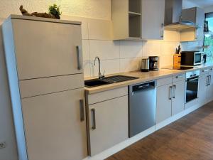 a kitchen with white cabinets and a sink at Gästezimmer Flechtorf in Lehre +3 photos