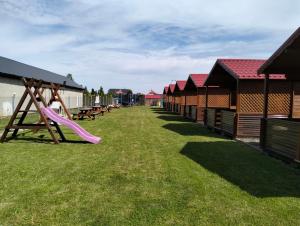 a playground with a slide in the grass at Domki letniskowe Wrzoski in Kamień Pomorski +4 photos