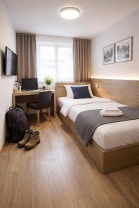 a bedroom with two beds and a desk with a laptop at Am Silbersee in Hochheim am Main