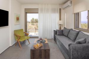 a living room with a gray couch and a chair at Utopia Luxury Villas in Gouves