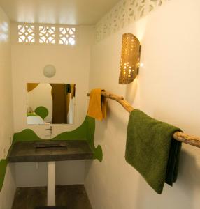 uma casa de banho com uma toalha verde e um espelho em Red Pepper Popoyo em Popoyo