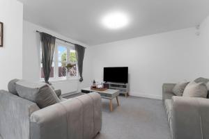 a living room with two couches and a tv at Buie's Runway Retreat in EDI