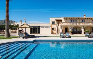 a swimming pool in front of a house at Catalina in Alcudia