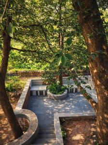 a garden with two trees and a stone pathway at MAK Mansion in Kotikulam