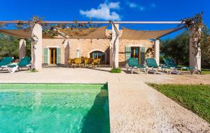 a house with a pool and chairs and a tent at Ses Fonolleres in Son Servera