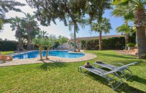 a resort yard with a swimming pool and palm trees at Can Gual in Inca