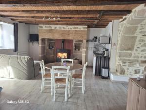 a living room with a table and chairs and a fireplace at Le Cosy in Sousceyrac