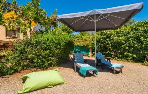 an umbrella and two chairs and a pillow on the ground at Cas Nets in Llucmajor