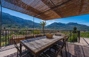 a wooden table and chairs on a balcony with mountains at Arbona Soller in Sóller
