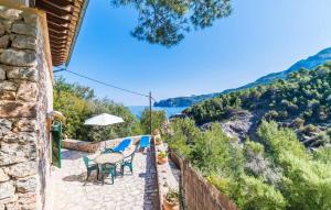 a patio with tables and chairs and a view of the water at Antonio in Deia