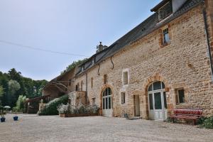 a brick building with a bench in front of it at Moulin de Vézelay - Maison d'hôtes in Fontenay-près-Vézelay