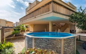 a swimming pool in front of a house at Es Ganxo House in Porto Cristo