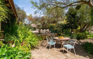 a table and chairs in a yard with trees at Can Pintad in Ruberts