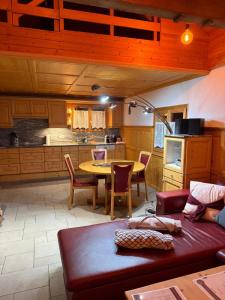 a living room with a table and a kitchen at Panorama-Chalet Unterbach in Hinwil