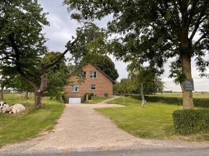 a dirt road leading to a brick house at Beimannskath in Kalkar