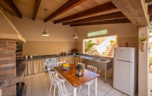 a kitchen with a wooden table and a white refrigerator at Casa Hermosa in Capdepera