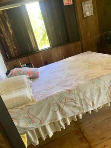 a bed in a room with a window at Fazenda Shalom in Tucano