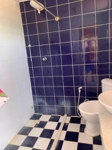 a blue tiled bathroom with a toilet and a sink at Fazenda Shalom in Tucano +5 photos