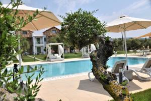 a pool with chairs and an umbrella next to a resort at Messinian Horizons in Marathopoli