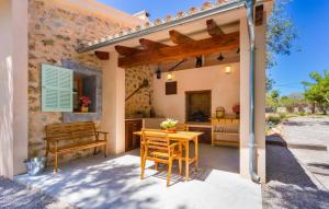a patio with a wooden table and a bench at Na Mikeleta in Capdepera