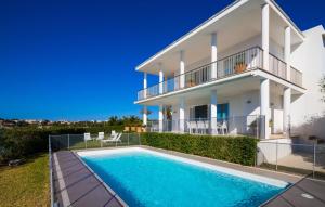 a villa with a swimming pool and a house at Esperanza in Portocolom
