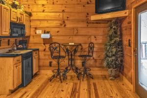 a kitchen with wooden walls and a table and stools at Riverfront Lodge in Tellico Plains
