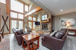 a living room with leather furniture and a stone fireplace at American Eagle Lodge by Railey Vacations in McHenry